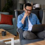 un homme sur une chaise avec un ordinateur portable