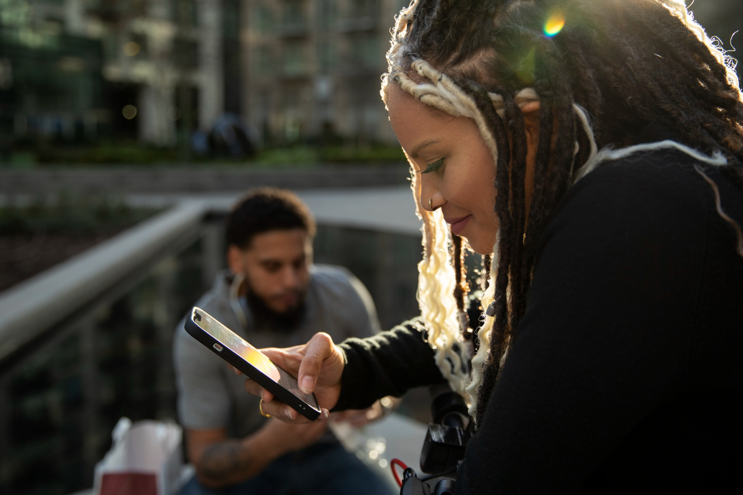 une fille utilise un téléphone et sourit